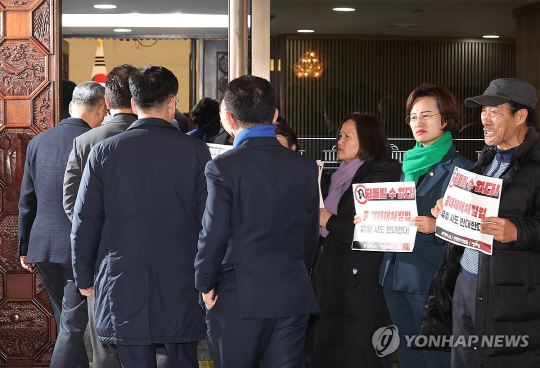 1일 국회에서 열린 더불어민주당 의원총회 앞에서 정의당과 노동계 관계자들이 회의장으로 향하는 의원들을 향해 중대재해처벌법 유예 반대 입장을 피력하고 있다. 연합뉴스